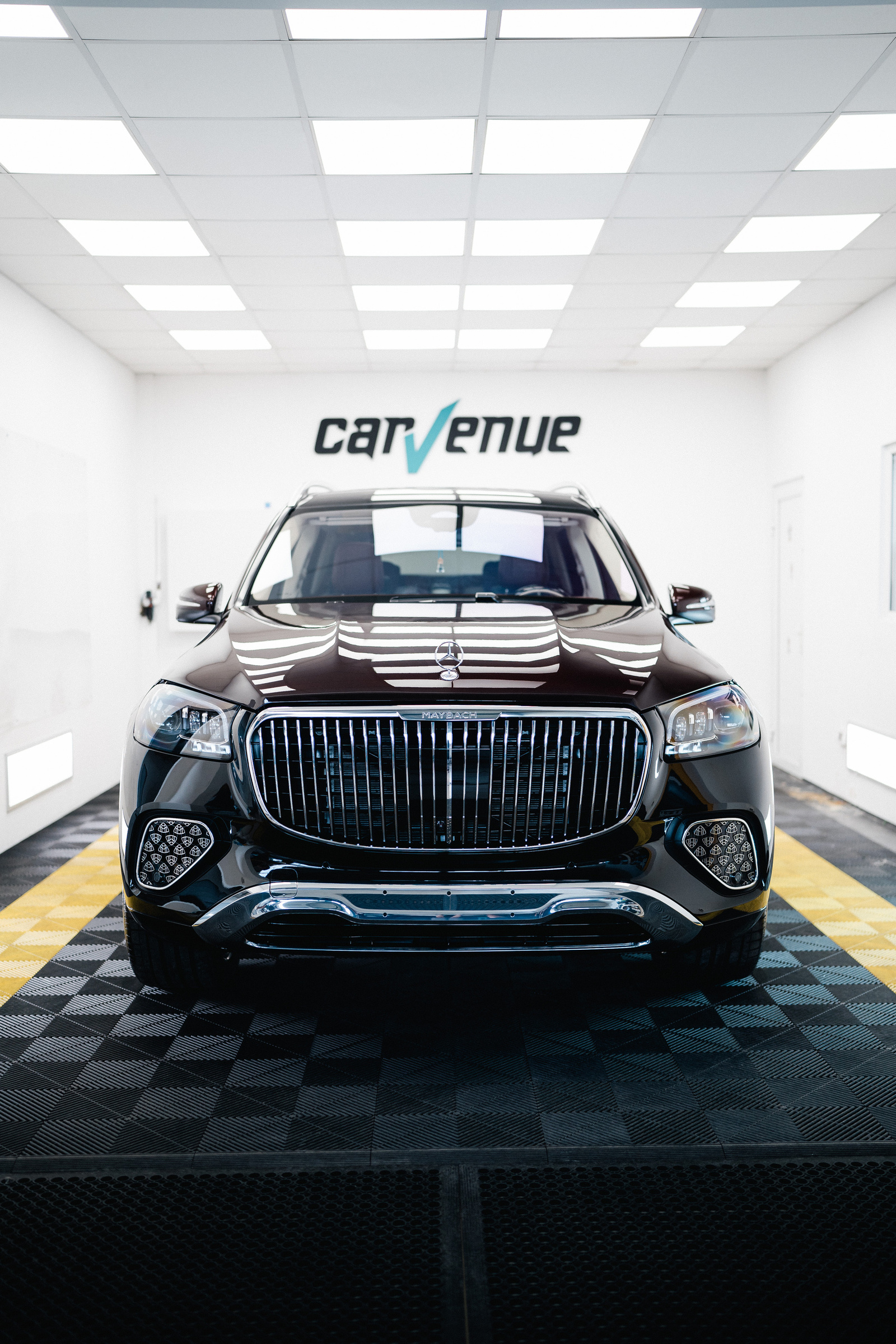Front view of a Mercedes-Maybach S-Class in the CarVenue studio, its dark paint reflecting the ceiling lights