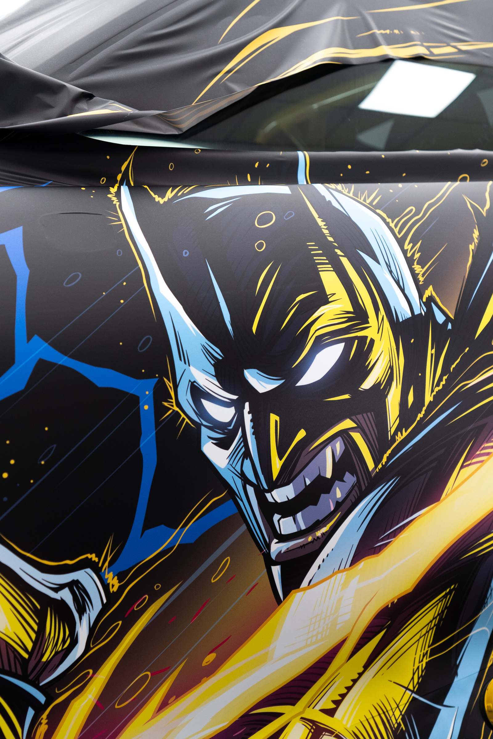 Close-up of a Porsche 911 wrap: Batman artwork on the side, with the roof film not yet laid down